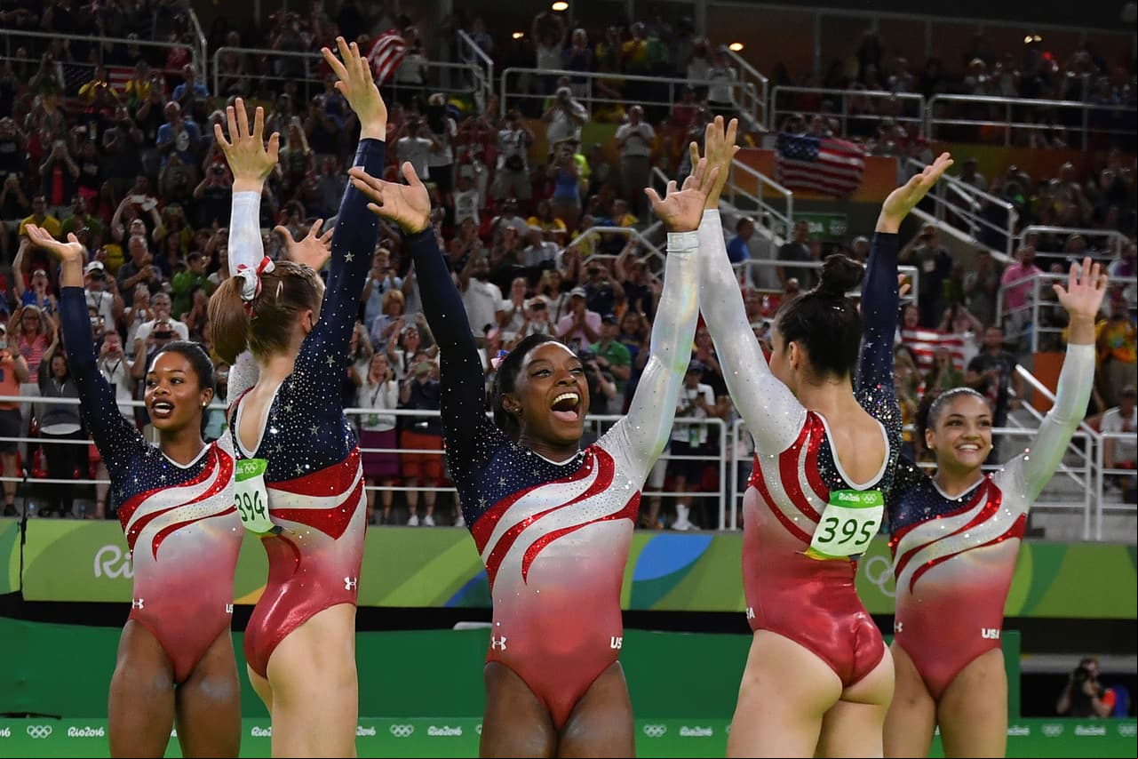 La atleta de 19 años celebra con sus compañeras de equipo la medalla de oro.