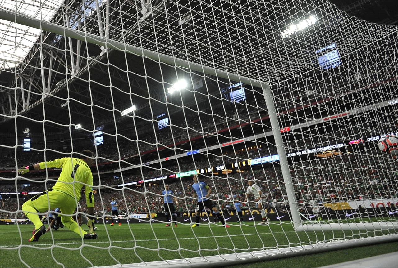 El portero de Uruguay, Fernando Muslera ve pasar el balón a gol, tocado por su compañero de equipo Alvaro Pereira.